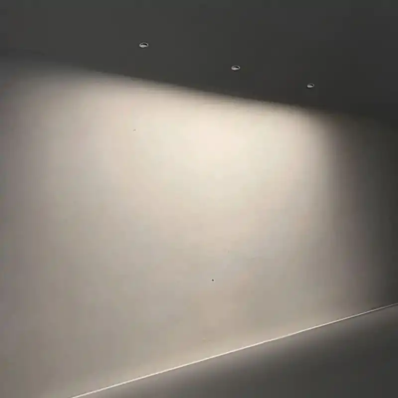 Unique modern recessed lighting brightens minimalist interior space efficiently.